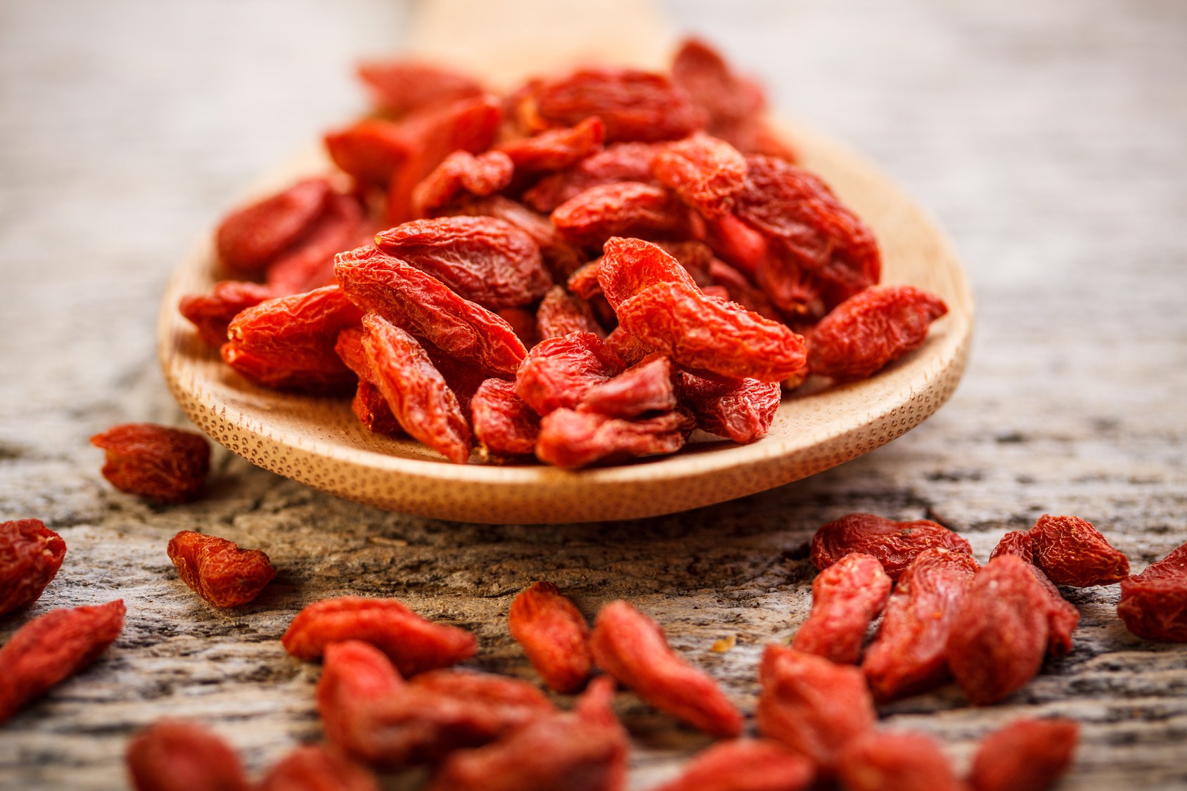 Red dried goji berries in wooden spoon